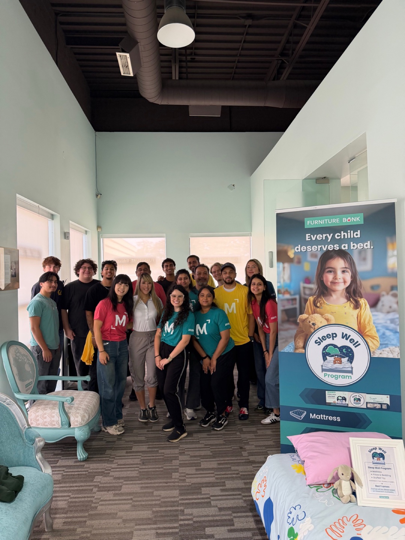 Furniture Bank volunteers beside the Sleep Well program display