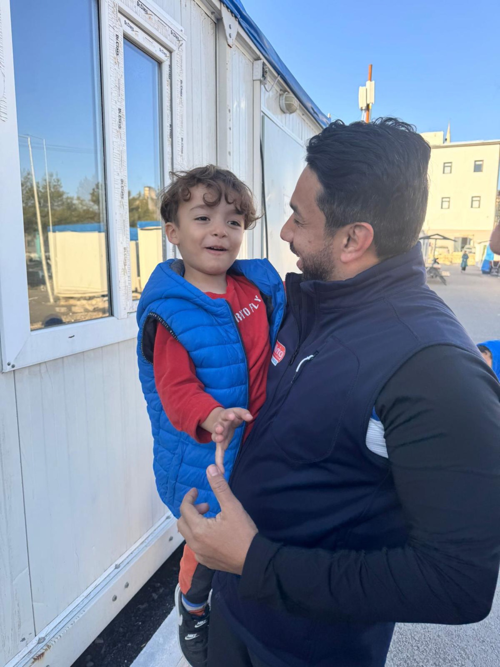 Syed Najam spending time with a child in temporary housing after the earthquakes in Türkiye